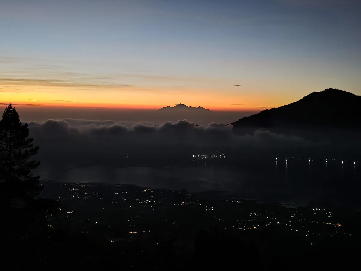 Partway up the mountain before sunrise, the lights of the towns below still on