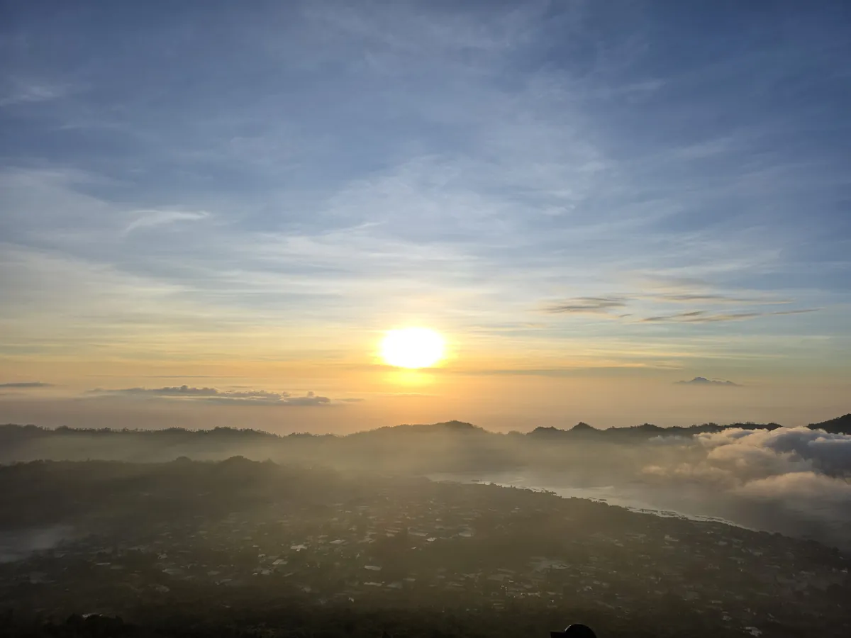 The sun rising above a layer of cloud seen from the mountain