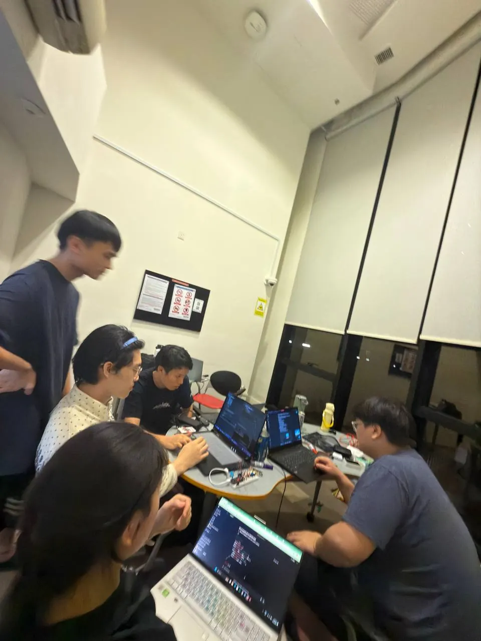 The team working on laptops in a room during the hackathon