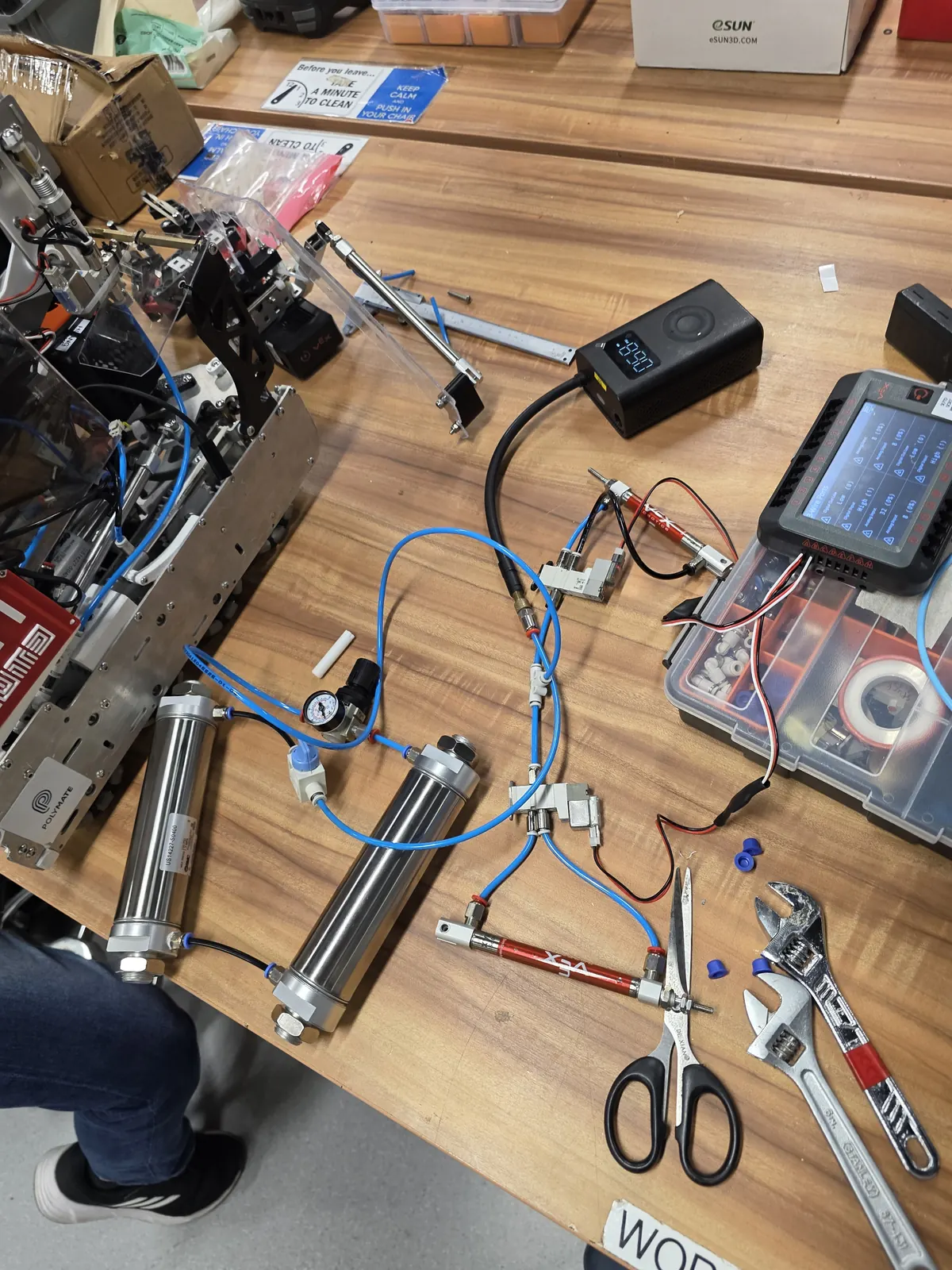Pneumatic cylinders, wiring and components laid out on a table