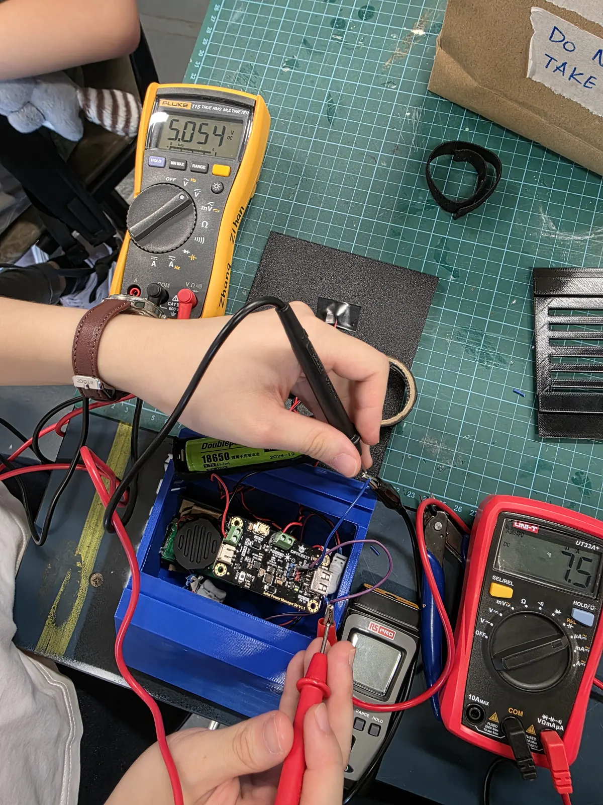 Multimeter probes on the assembled circuit during bench testing